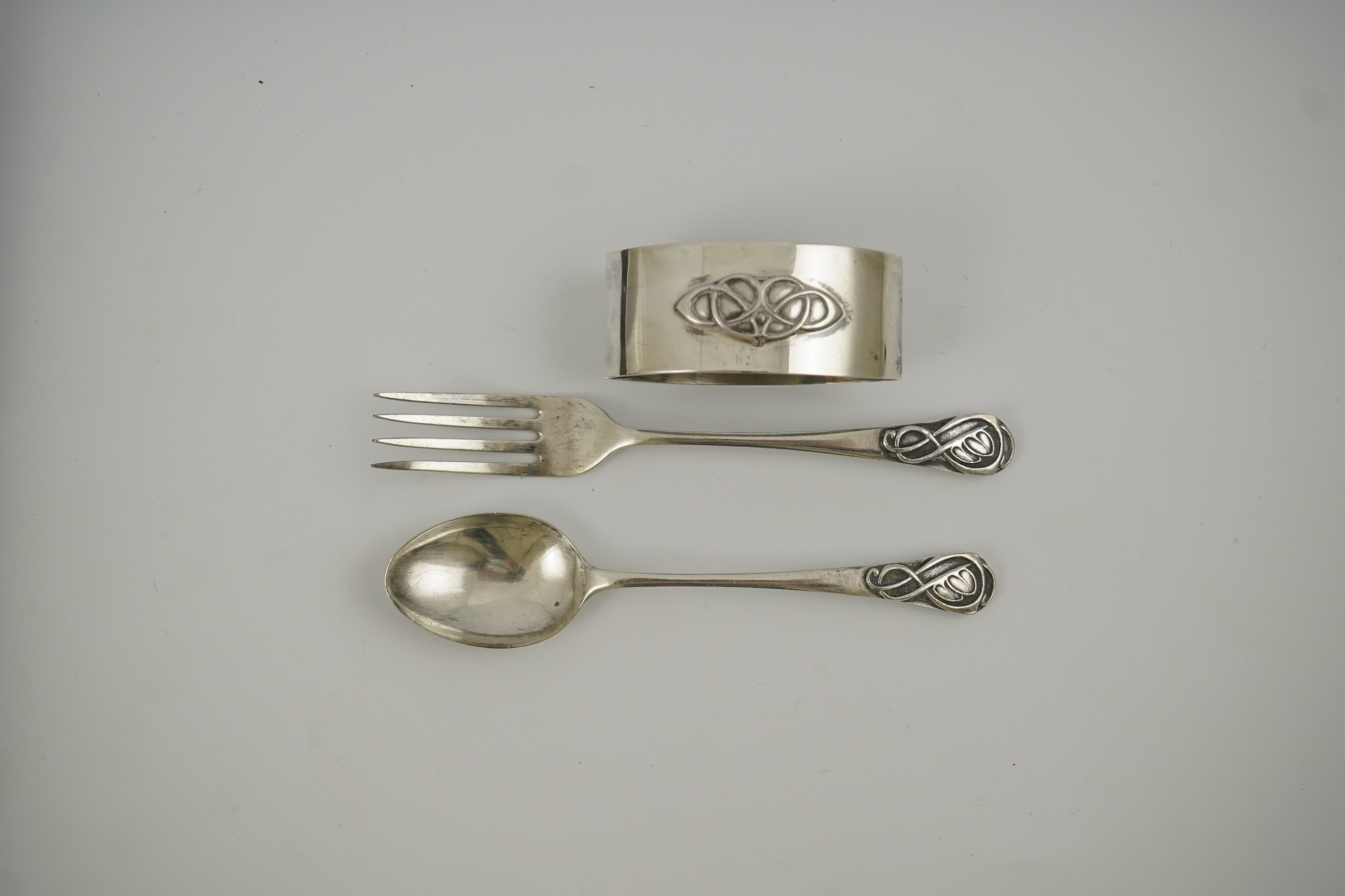 A 1930's Arts & Crafts Liberty & Co cased silver three piece christening set